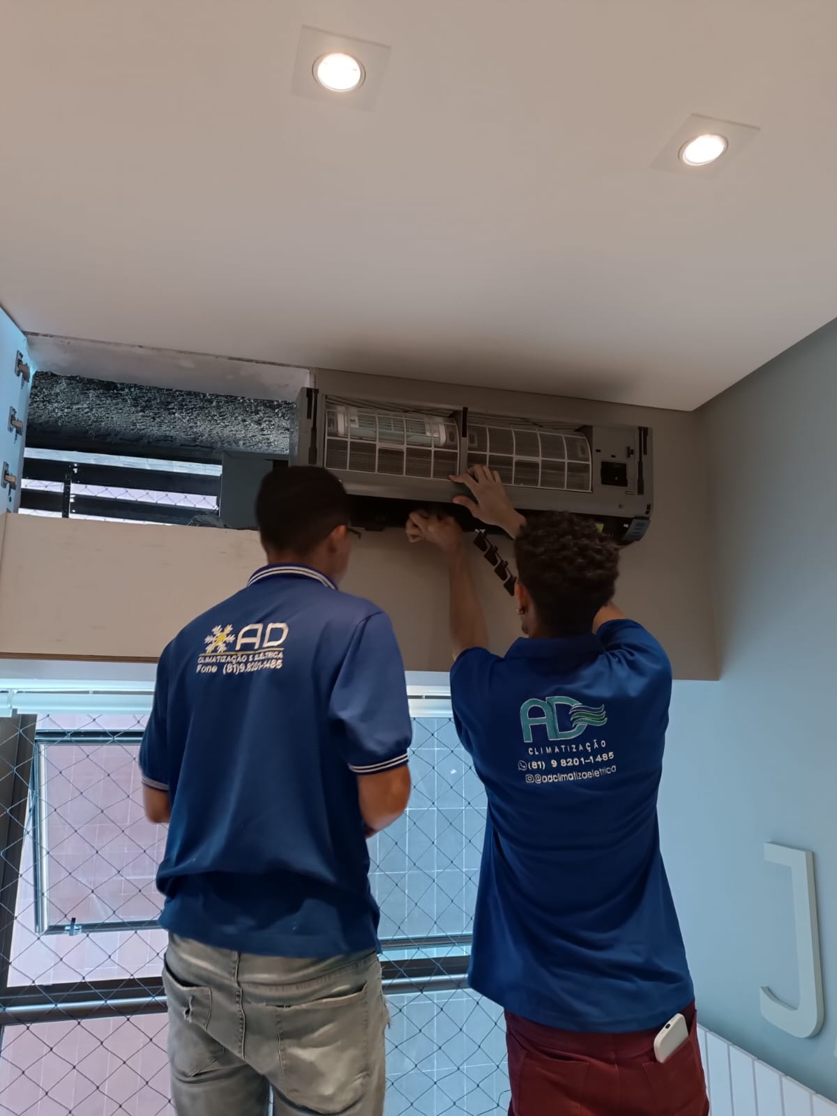 Duas pessoas instalando componentes elétricos