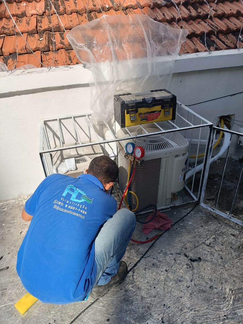 Pessoa acocorada instalando no teto - serviços elétricos